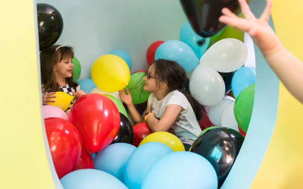 Dos chicas lindas hablando mientras juegan con globos multicolores —  Fotos de Stock