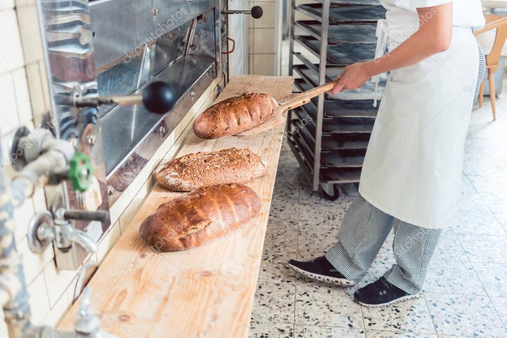 Woman in bakery putting bread on board