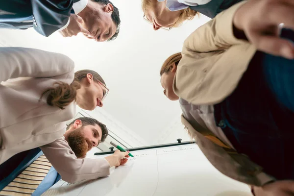 Vista de bajo ángulo de un equipo internacional trabajando juntos durante —  Fotos de Stock