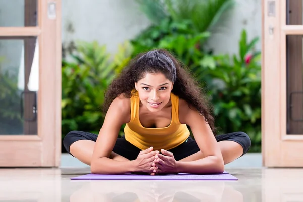 Jonge vrouw doet stretching oefening binnenshuis — Stockfoto