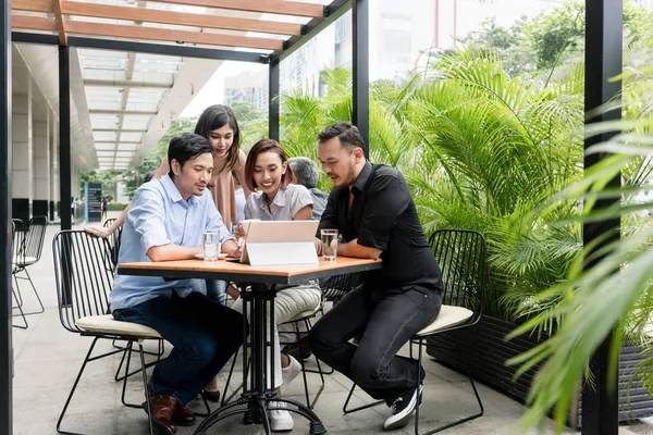 Vier Aziatische jonge vrienden glimlachen tijdens het kijken naar elkaar grappige o — Stockfoto
