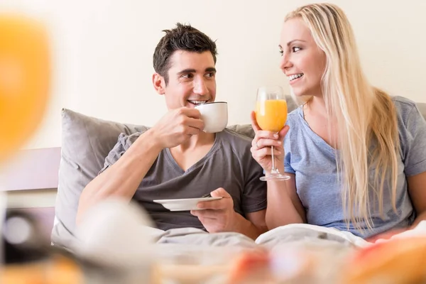 Feliz jovem casal beber café e suco de laranja — Fotografia de Stock