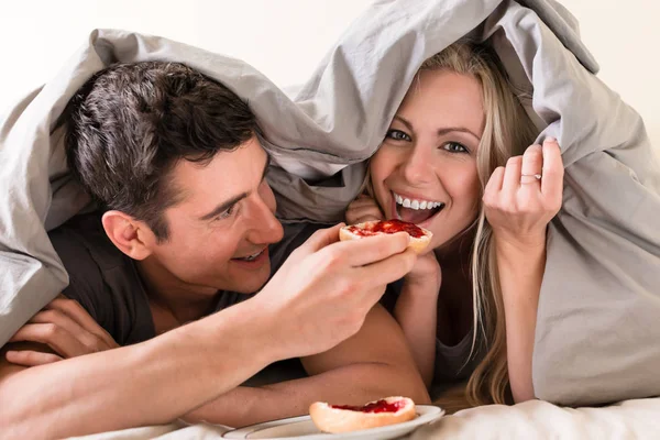 Casal comer pão com geléia de morango — Fotografia de Stock