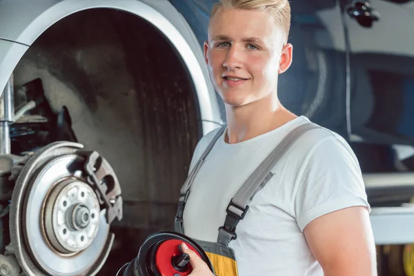 Meccanico dedicato che lavora in una moderna officina di riparazione di automobili con — Foto Stock