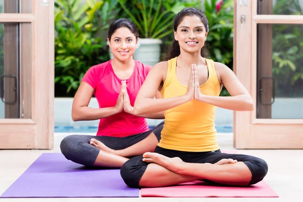 Lotus pozisyonu yoga uygulamaları sırasında iki kadın — Stok fotoğraf