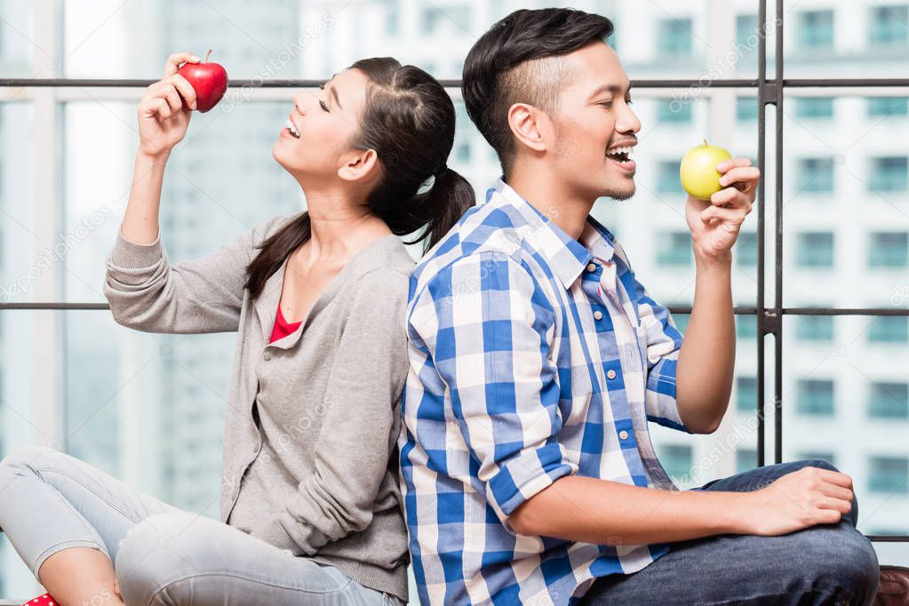 Asian couple having apples as healthy snack