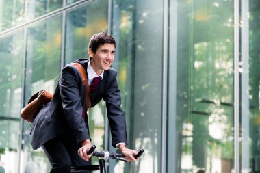 young man riding bicycle to workplace  clipart