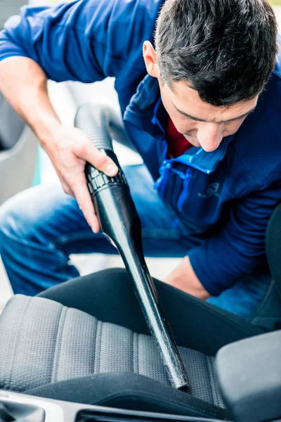 Man met vacuüm voor het reinigen van de auto — Stockfoto