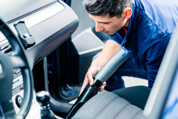 Hombre utilizando el vacío para la limpieza de coches — Foto de Stock