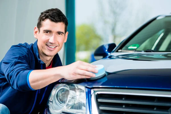 Young man polishing blue car — Stock Photo, Image