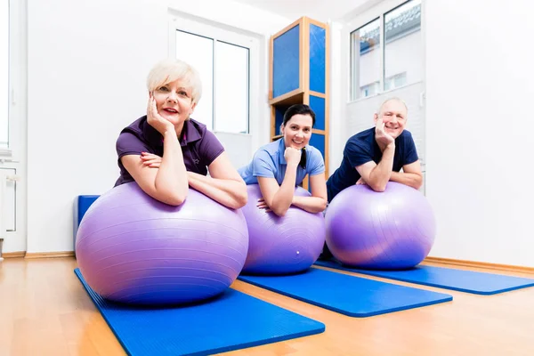 Physio mostrando exercícios de casal sênior — Fotografia de Stock