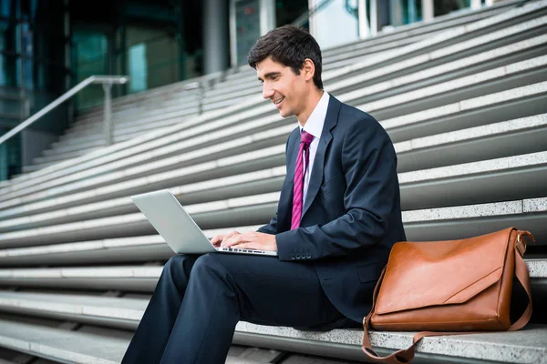 Jovem empresário usando laptop — Fotografia de Stock