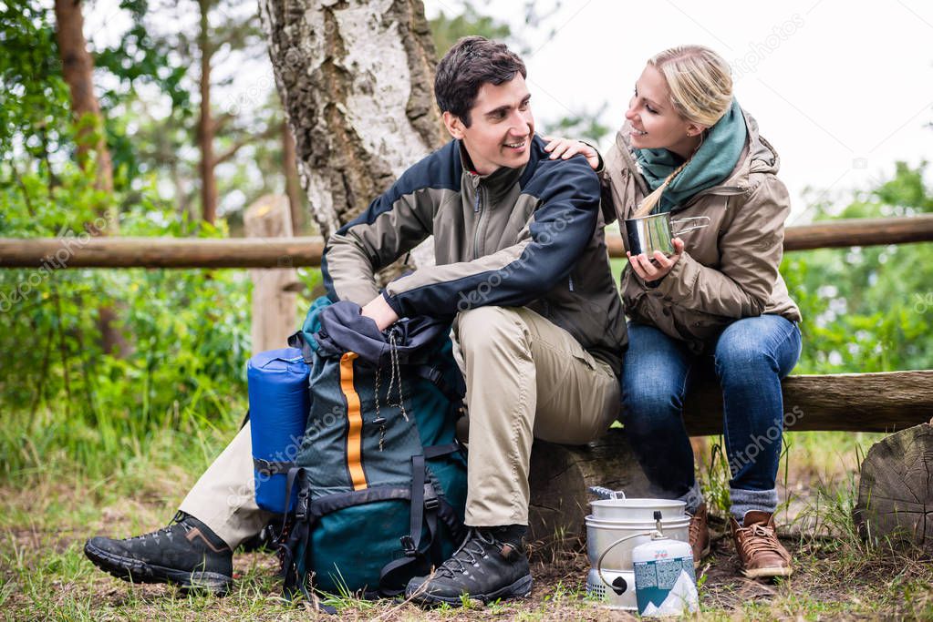 Man and woman take break from hiking  