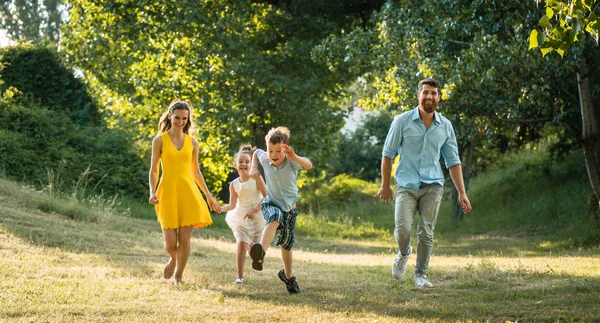 Active young parents with a healthy lifestyle running together w — Stock Photo, Image