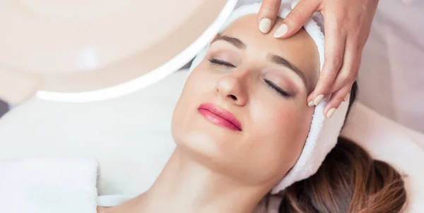 Жінка розслабляється під час омолоджуючого масажу обличчя — стокове фото