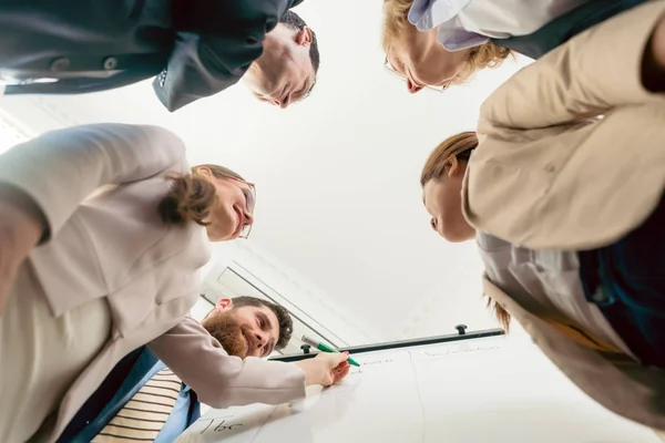 Low-angle view of an international team working together during — Stock Photo, Image