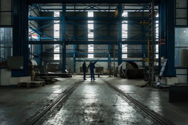 İki işçi endüstriyel bir salonu iç üretim sürecinde planlama