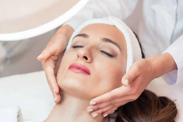 Bella donna rilassante durante il massaggio facciale per il ringiovanimento — Foto Stock