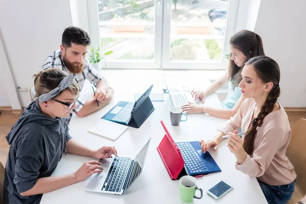 Hängiven ung kvinna redigerar ett dokument i en modern office spac — Stockfoto