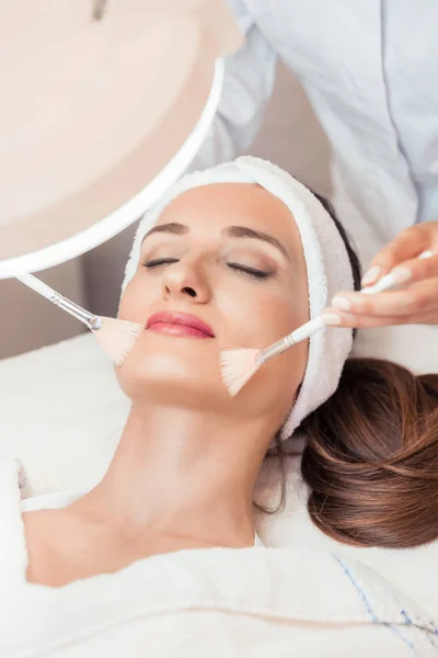 Hermosa mujer durante el masaje facial anti-envejecimiento en un moderno cos —  Fotos de Stock