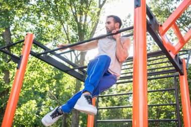 Şaşırtıcı pull-up değişim sırasında aşırı yapan güçlü genç erkek