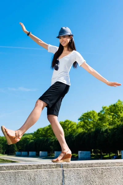 Asiática mujer de pie en una pierna al aire libre —  Fotos de Stock