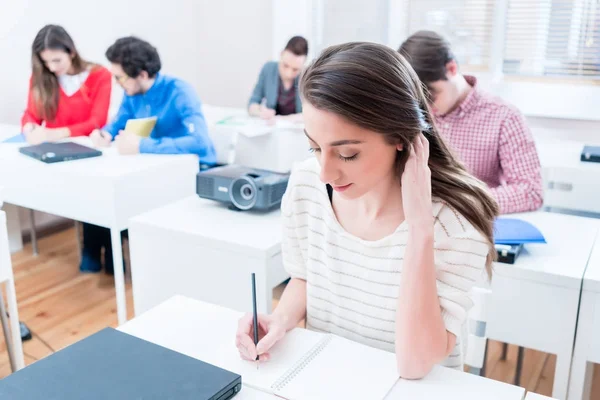 Studerande kvinna skriver test i seminarierum för universitet — Stockfoto