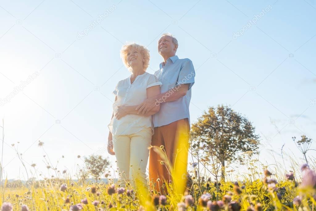 elderly couple standing together on field