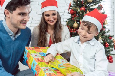 Çocuk ailesiyle birlikte Noel hediyesi unwrapping