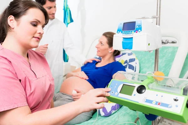 Donna incinta in sala parto con medico e infermiera — Foto Stock