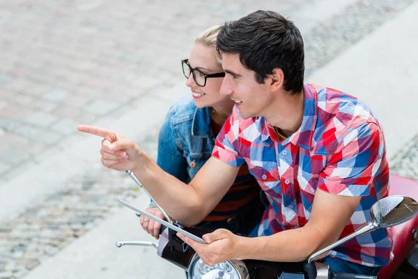 Pareja en viaje urbano planeando su recorrido Vespa utilizando tablet PC — Foto de Stock