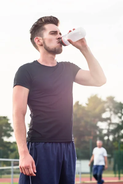Ember iszik víz üveg alatt sport — Stock Fotó