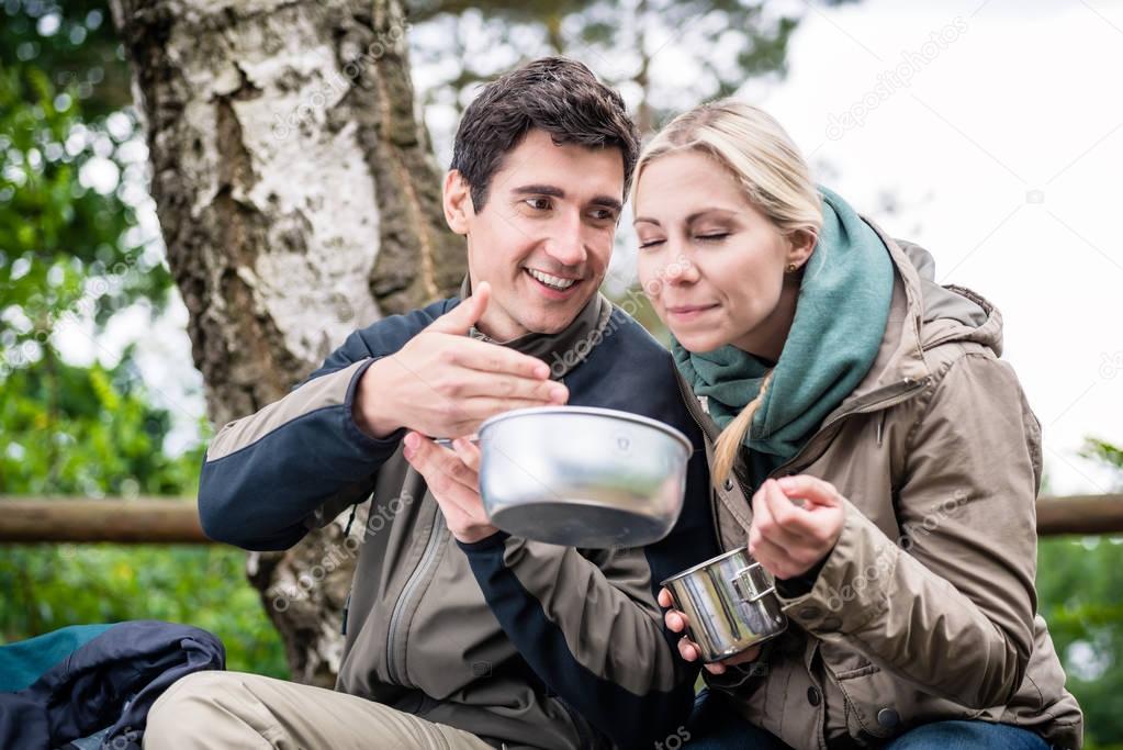 Backpackers eating out of tin bowl