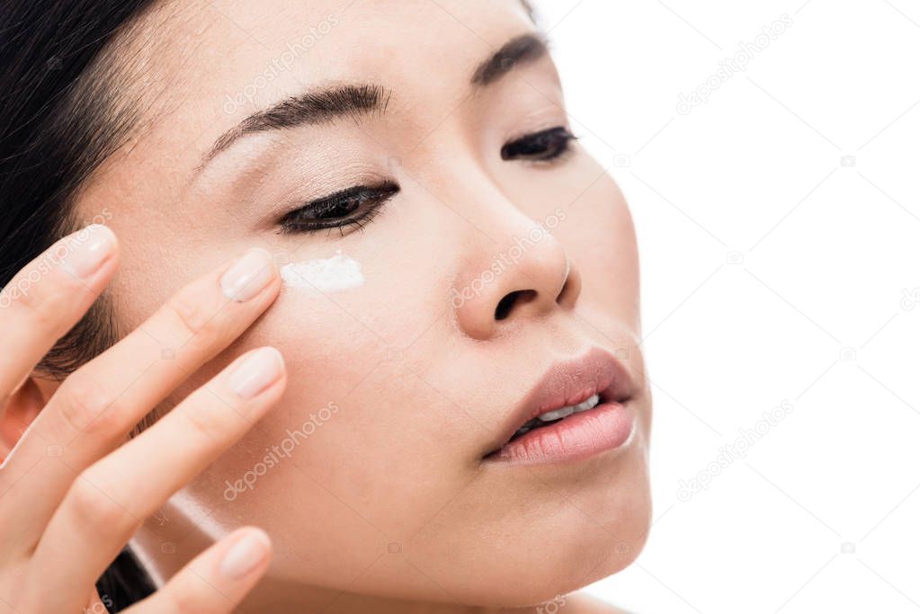 Young woman applying anti-wrinkles eye moisturizer
