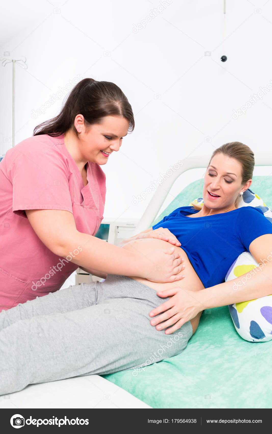 Midwife Or Nurse And Pregnant Woman In Delivery Room Stock