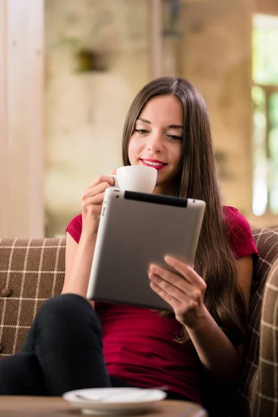 Giovane donna contemporanea che legge su tablet in una caffetteria — Foto Stock