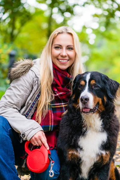 Kvinnan gå ut med hunden på koppel i park — Stockfoto