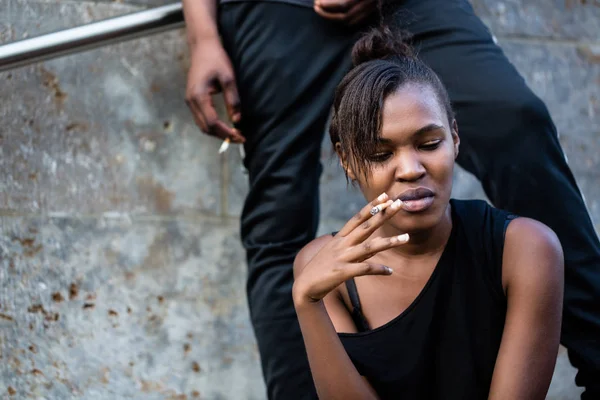 Jovem afro-americana mulher e homem fumando ao ar livre no cit — Fotografia de Stock