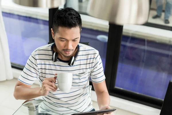 Asiatischer Mann trinkt Kaffee in seinem Haus — Stockfoto