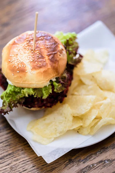 Nahaufnahme von Burger mit grünem Salat und Kartoffelchips — Stockfoto