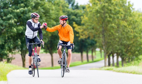 Ciclisti da corsa dopo lo sport e dando il cinque — Foto Stock