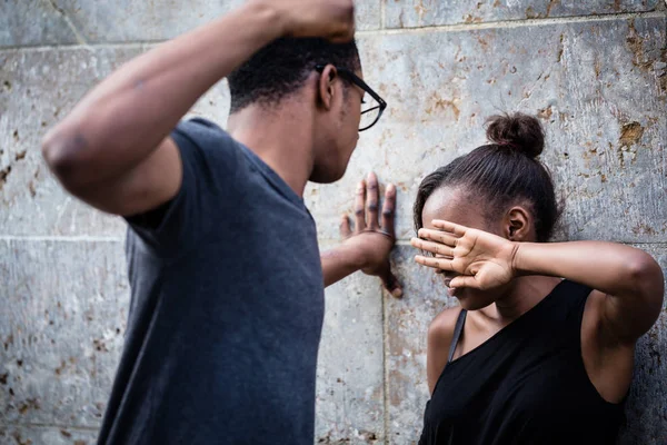 Жестокий молодой человек угрожает своей девушке своим кулачным перевесом — стоковое фото