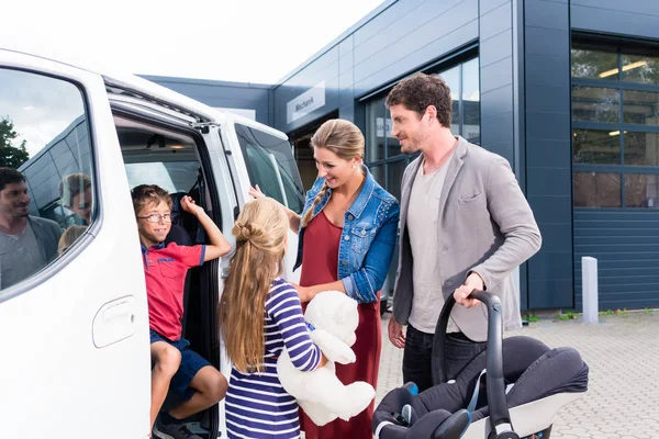 Familia revisando coche nuevo en concesionario de coches — Foto de Stock