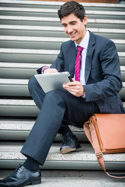 Businessman using a tablet for communication or data storage out — Stock Photo, Image