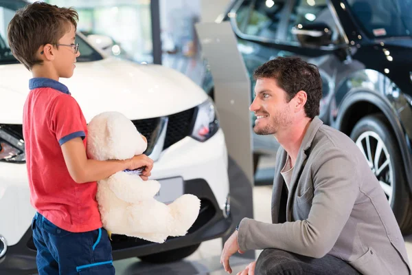 Pai com filho no carro revendedor showroom compra de automóveis — Fotografia de Stock