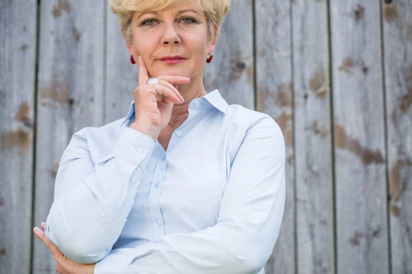 Portrait of an active senior woman looking at camera with a pens — Stock Photo, Image