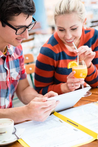 Couple in street cafe watching pictures of holidays — Stock Photo, Image