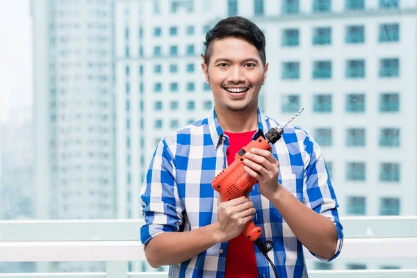 Young indonesian man with power drill — Stock Photo, Image