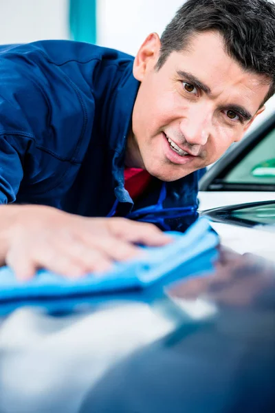 Homme utilisant une serviette absorbante pour sécher la surface d'une voiture — Photo