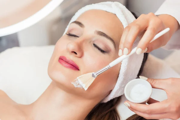 Close-up of a beautiful woman relaxing during facial treatment i — Stock Photo, Image